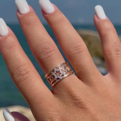 Close-up of the two-tone Star of David Eternal Ring worn against a Mediterranean seaside background