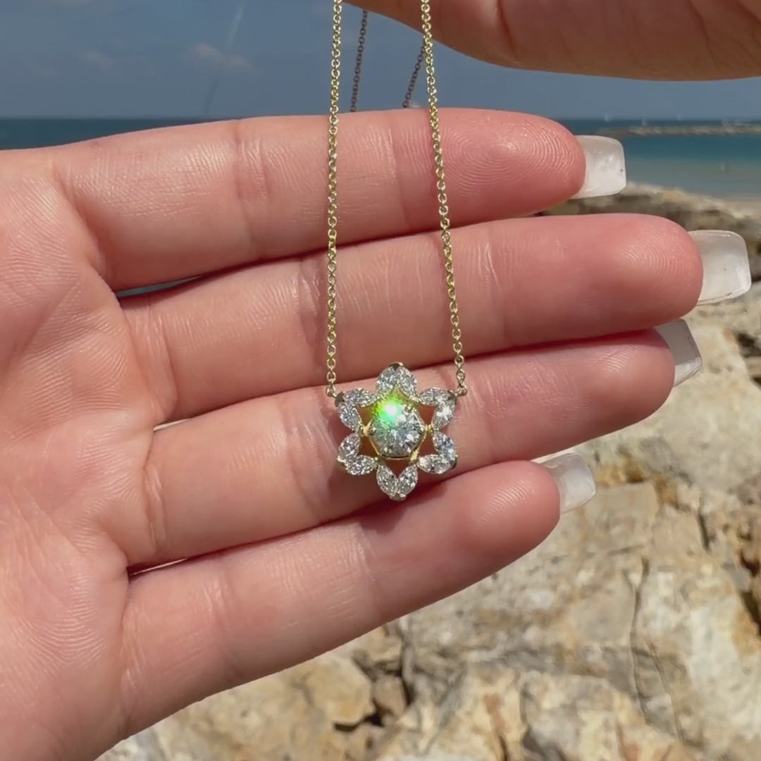 14k Gold Two-tone Star of David Legacy Necklace with marquise diamonds held beside the Mediterranean Sea