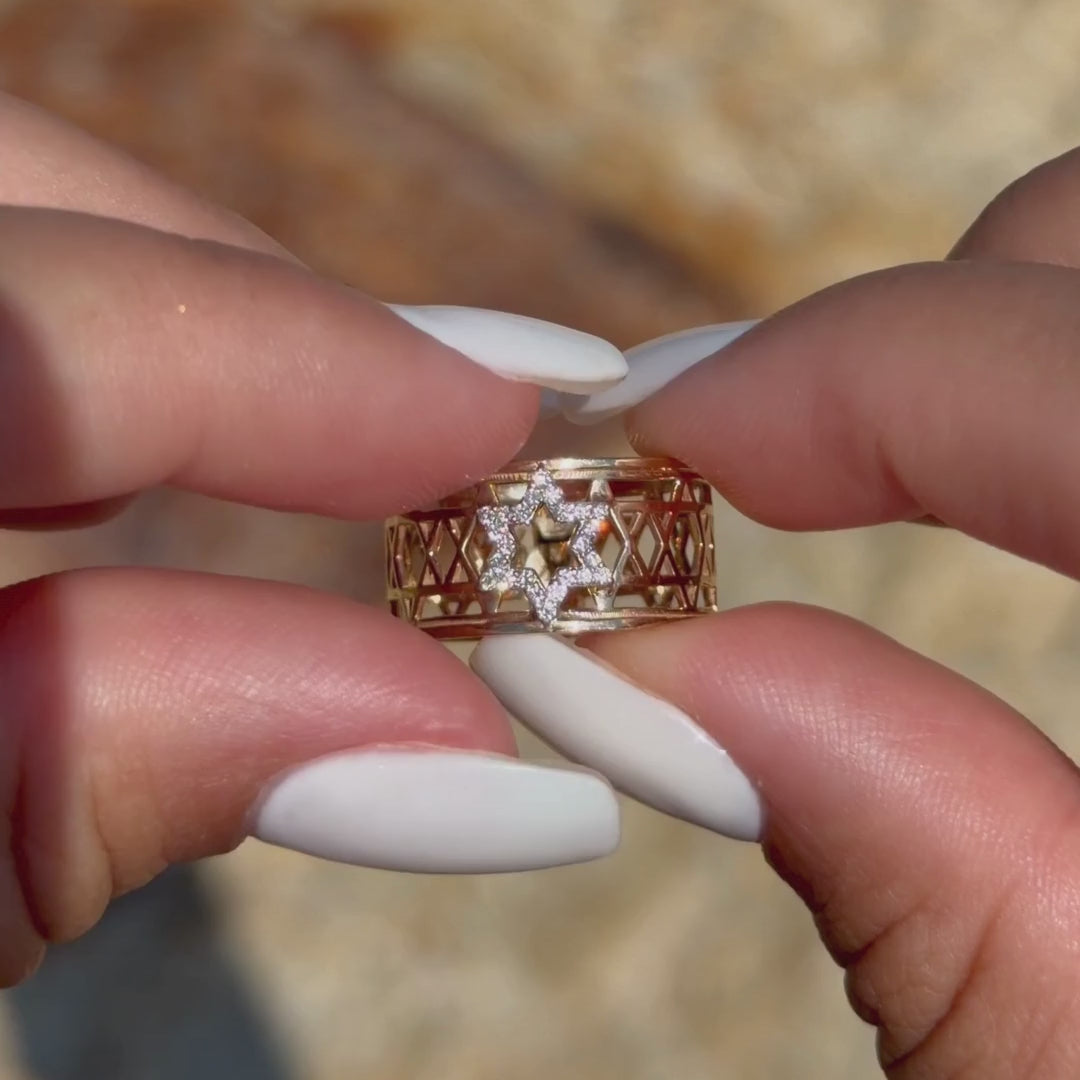 Hand rotating the Star of David Eternal Ring to show its diamond star and openwork gold band